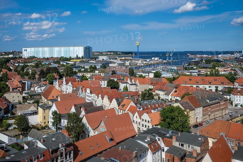 Wismar, Mecklenburg-Western Pomerania, Germany, city view of Wismar's old town centre, behind MV Werften Wismar-Rostock-Stralsund. The cruise ship shipyard still employs around 700 people, compared to 1, 300 in front of the shipbuilding crisis, making it one of Wismar's largest employers. The newly built facilities in Wismar also include the covered building dock, whose hall is 72 metres high, 155 metres wide and over 395 metres long. The shipyard has belonged to the Malaysian-Chinese shipping company Genting Hong Kong since March 2016. Genting founded the new MV Werften, which in future will comprise the Wismar, Warnemünde and Stralsund sites with a total of around 1, 700 employees The shipyard group filed for insolvency in January 2022 and the shipyard was sold to Thyssenkrupp Marine Systems as a result in June 2022, Europe