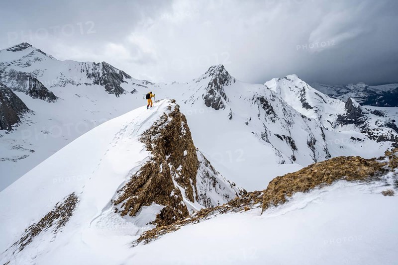 Ski tourers climbing the Niesehorn, Wildhorn summit behind, snow-covered mountain landscape, dramatic clouds, Bernese Alps, Bernese Oberland, Switzerland, Europe