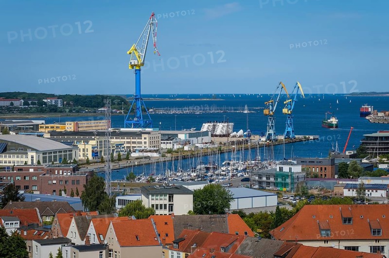 Wismar, Mecklenburg-Western Pomerania, Germany, city view of the old town and harbour of Wismar, MV Werften Wismar-Rostock-Stralsund in the background. The cruise ship shipyard still employs around 700 people, compared to 1, 300 in front of the shipbuilding crisis, making it one of Wismar's largest employers. Since March 2016, the shipyard has belonged to the Malaysian-Chinese shipping company Genting Hong Kong. Genting founded the new MV Werften, which in future will comprise the Wismar, Warnemünde and Stralsund sites with a total of around 1, 700 employees The shipyard group filed for insolvency in January 2022 and the shipyard was sold to Thyssenkrupp Marine Systems in June 2022 as a result, Europe