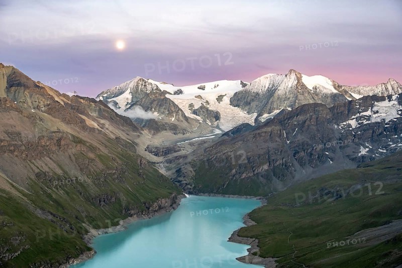 Mountain landscape with turquoise blue reservoir Lac des Dix and summit Mont Blanc de Cheilon, moon above mountain peaks at sunset, Hérménence, Valais Alps, Valais, Switzerland, Europe