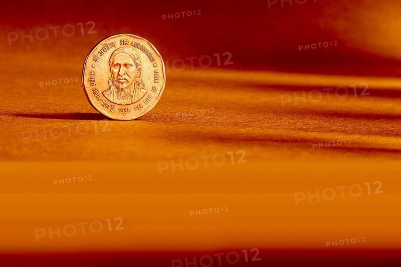 One Indian currency two rupees coin backside embossed Sri Aurbindo all life is yoga 1998 on orange background