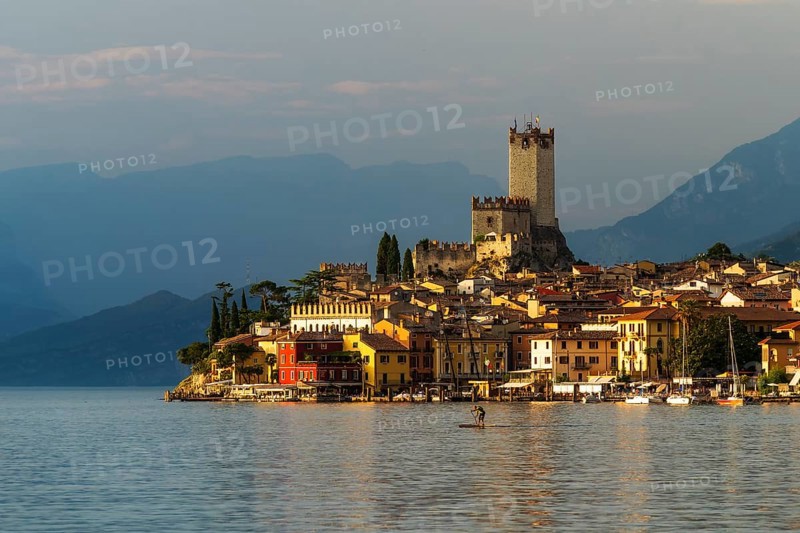 Scaliger castle and city malchesine at sunset with stand up paddle