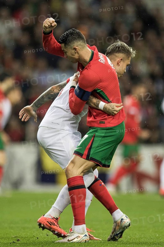 Football match, captain Cristiano RONALDO CR7 Portugal right, looking from behind in a duel with Kamil PIATKOWSKI Poland, Kamil PIATKOWSI Poland holds Cristiano RONALDO Portugal and Cristiano RONALDO Portugal raises his right arm and fist up behind him ready to lunge, Estadio do Dragao, Porto, Portugal, Europe