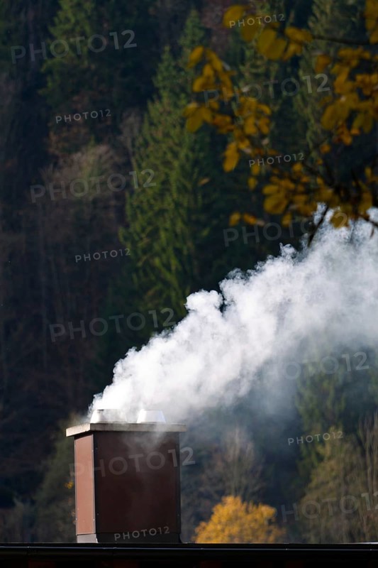 Smoking chimney of a residential building. Exhaust fumes and environmental protection Austria