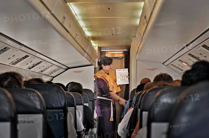 Flight attendant, obsolete stewardess explaining the function of the life jacket, propeller aircraft, Jet Prop Fokker 50, former Riau Airlines, passengers, Flores Island, Indonesia, Asia