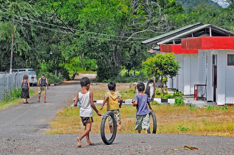Children playing with tyres, Labuan Bajo, Flores Island, Indonesia, Asia