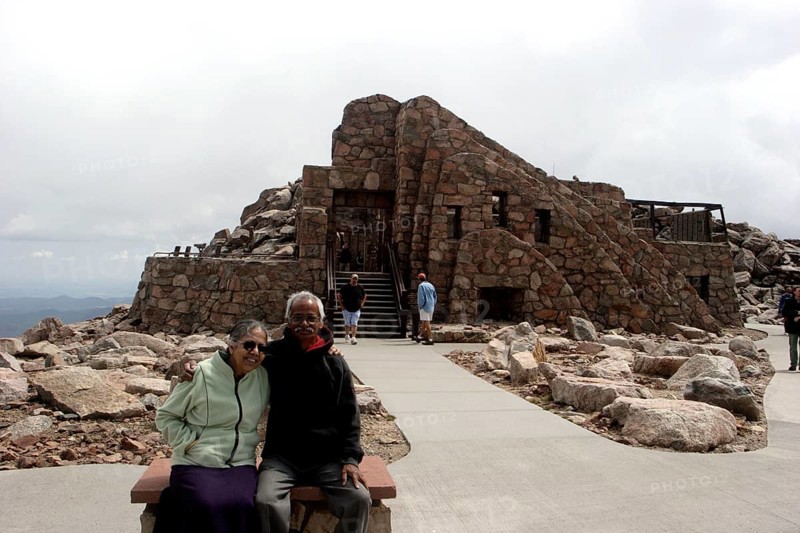Old man and woman sitting in front of Crest House built in 1939