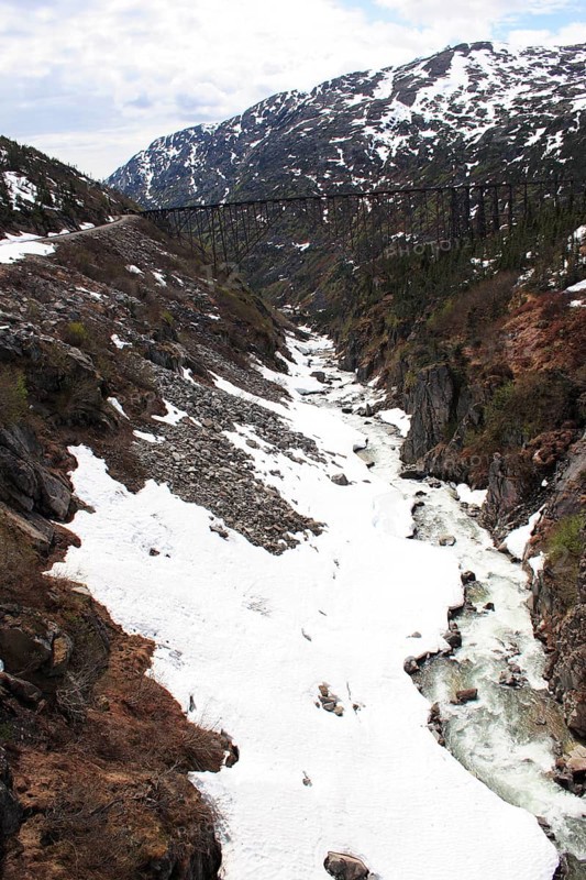 Snow capped mountains, A steel bridge constructed in 1901, tallest cantilever bridge in the world used until 1969, Skagway, Alaska, U.S.A. United States of America