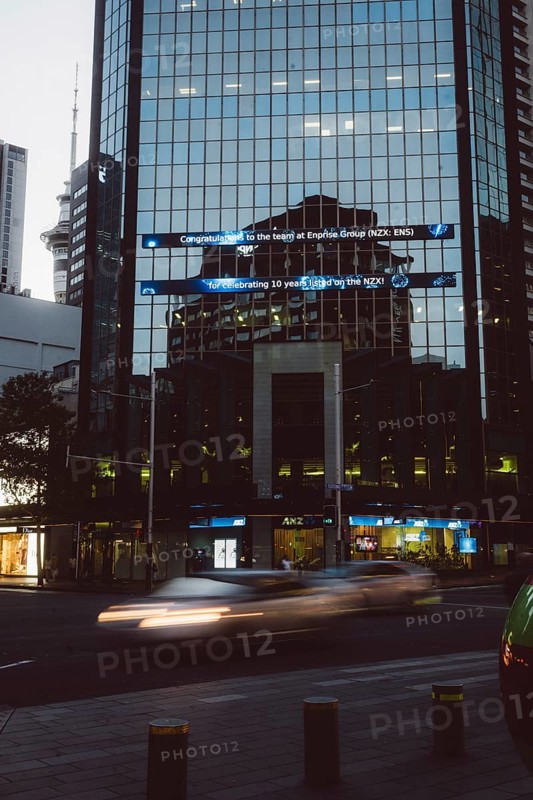 Reflective glass facade of a high-rise building in a city at night, light traces from passing cars, new zealand stock exchAuckland, New Zealand, Oceania