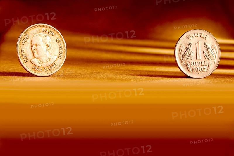 Double pair Indian currency one rupees coin front side and backside manner embossed Rajiv Gandhi 1944-1991 on orange background