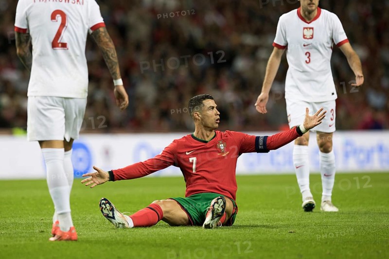 Football match, captain Cristiano RONALDO CR7 Portugal centre has just been fouled and is sitting on the ground, with his right arm up, head to the right looking at the referee shouting loudly with his mouth open and demanding a free kick, captain's armband, sequence 7, Estadio do Dragao, Porto, Portugal, Europe