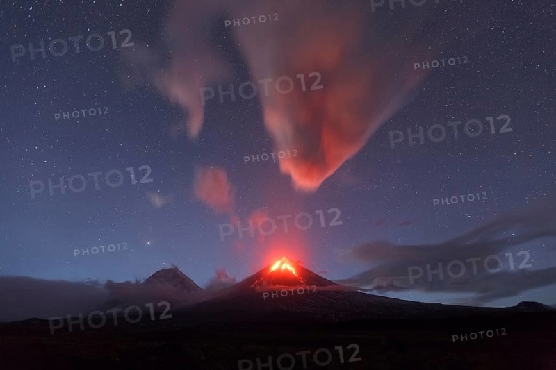 Beautiful volcanic landscape of Kamchatka Peninsula: night view of eruption active Klyuchevskaya Sopka or Klyuchevskoy Volcano. Eurasia, Russian Far East, Kamchatka Region, Klyuchevskaya Group of Volcanoes