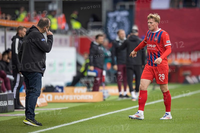 Football match, Mikkel KAUFMANN 1.FC Heidenheim right shows the direction to the coach Frank SCHMIDT 1.FC Heidenheim with his left arm, the latter points with his right index finger to his ear and signals that he is listening to him, football stadium Voith-Arena, Heidenheim