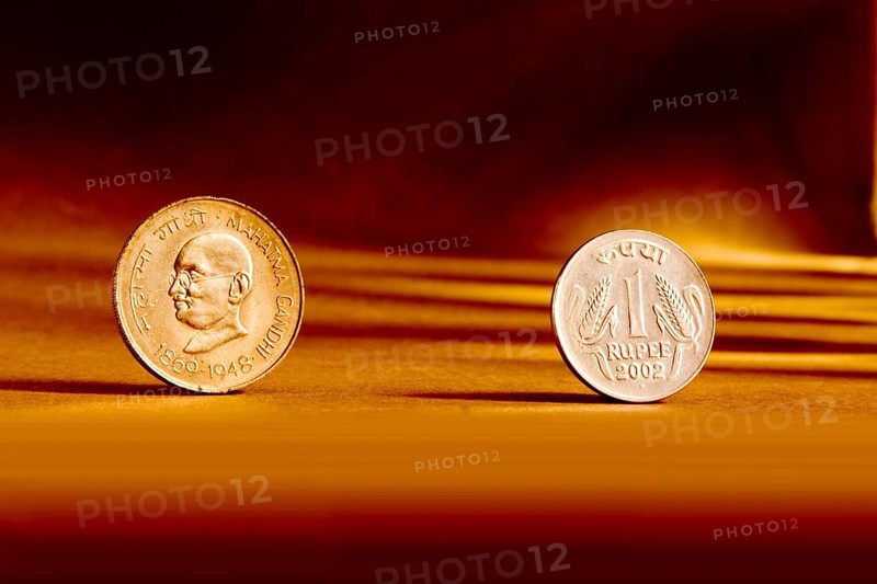 Double pair Indian currency one rupees coin front side and backside manner embossed Mahatma Gandhi 1869-1948 on orange background