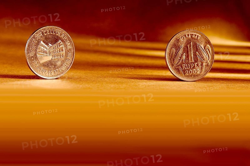Double pair Indian currency one rupees coin front side and backside manner embossed Cellular Jail Port Blair 1997 on orange background