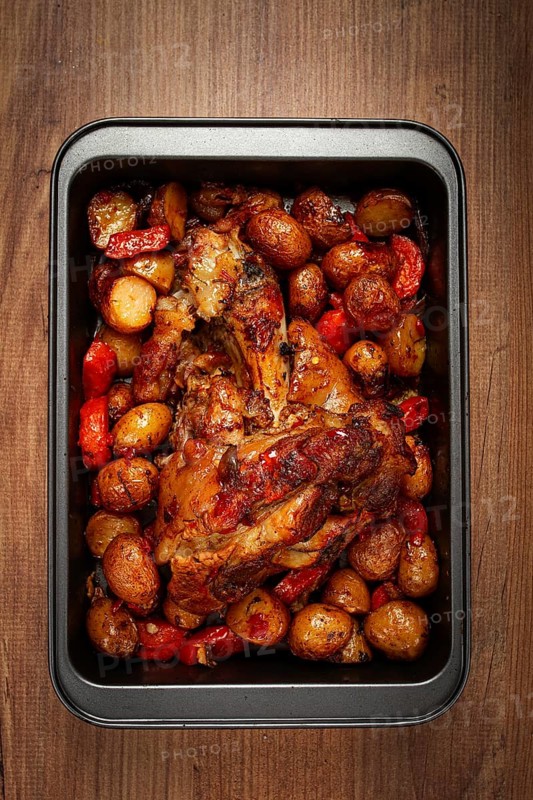 Pork knuckle, baked with vegetables, new potatoes, on a baking sheet, homemade, no people