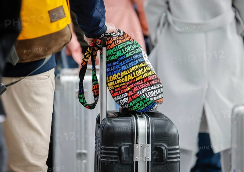 Düsseldorf, North Rhine-Westphalia, Germany - Düsseldorf Airport, Easter holidaymakers at the Condor check-in counter on their way to Majorca during the corona pandemic, hand luggage with Majorca written on it, in front of the flight to Spain and also in front of the return flight to Germany, air travellers must present a negative corona test