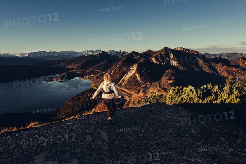 Trail running in autumn on the Jochberg on Lake Walchensee against the wonderful backdrop of the Alps, Bavaria, Germany, Europe