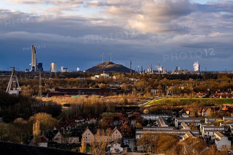 The Schüngelberg housing estate, in Gelsenkirchen-Buer, against the backdrop of the UNIPER coal-fired power station Gelsenkirchen-Scholven, power station units and cooling towers, headframe of the former Hugo coal mine, shaft 2, Scholven spoil tip with 2 wind turbines, on the right Ruhr Öl GmbH - BP Gelsenkirchen, refinery, North Rhine-Westphalia, Germany, Europe