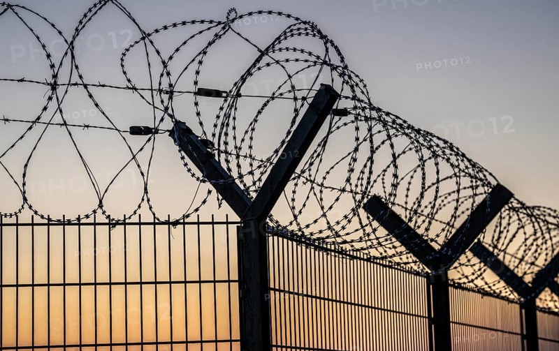 Symbolic image security, S-wire rolls, NATO wire, on a fence top, demarcation of a property, prevention of unauthorised access, strip steel wire with sharp blades