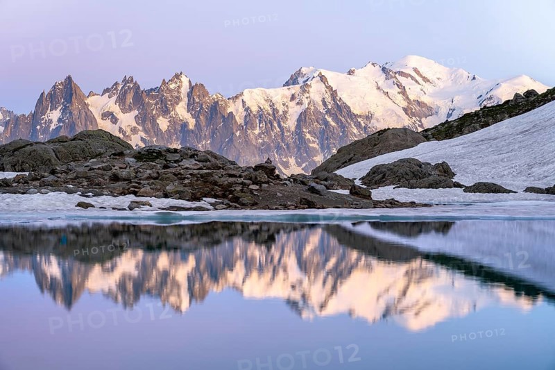 Evening mood with pink evening sky, mountain landscape at sunset, water reflection in Lac Blanc, mountain peaks Aiguille du Midi and Mont Blanc of the Mont Blanc massif, Chamonix-Mont-Blanc, Haute-Savoie, France, Europe