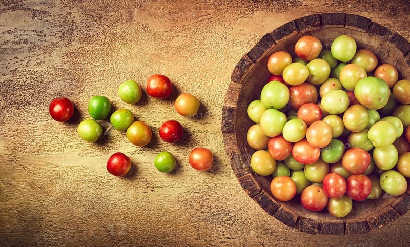 Cherry plum tkemali, fruit, plum variety, in a wooden plate, Georgian cuisine, top view, no people