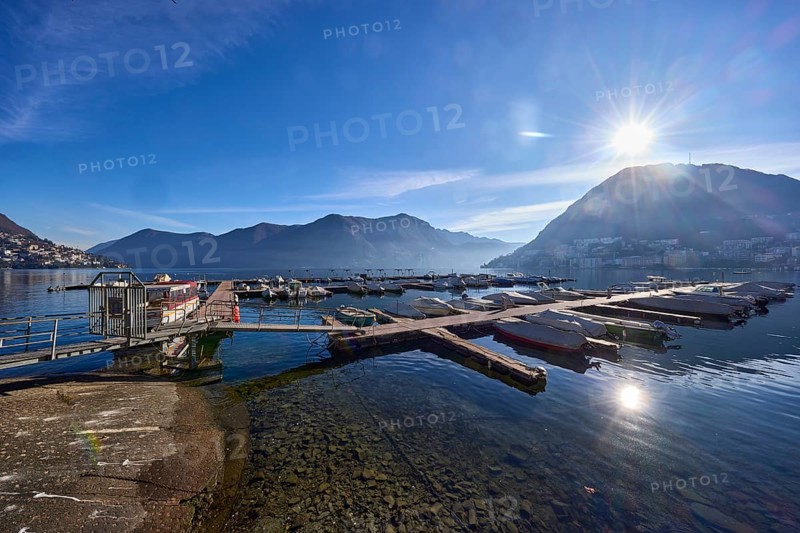 Marina, motorboats, lake, mountains, haze, backlight of the sun, blue sky with veil clouds, Lake Lugano, Lugano, district Lugano, canton Ticino, Switzerland, Europe