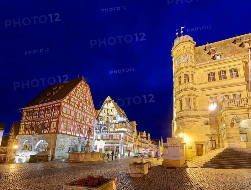 Town hall on the market square and half-timbered houses in Herrngasse in the old town of Rothenburg ob der Tauber, illuminated at night. Rothenburg, Bavaria, Germany, Europe