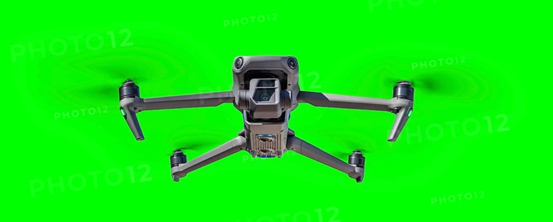 Isolated unmanned aircraft system (UAV) quadcopter drone in the air over A green screen
