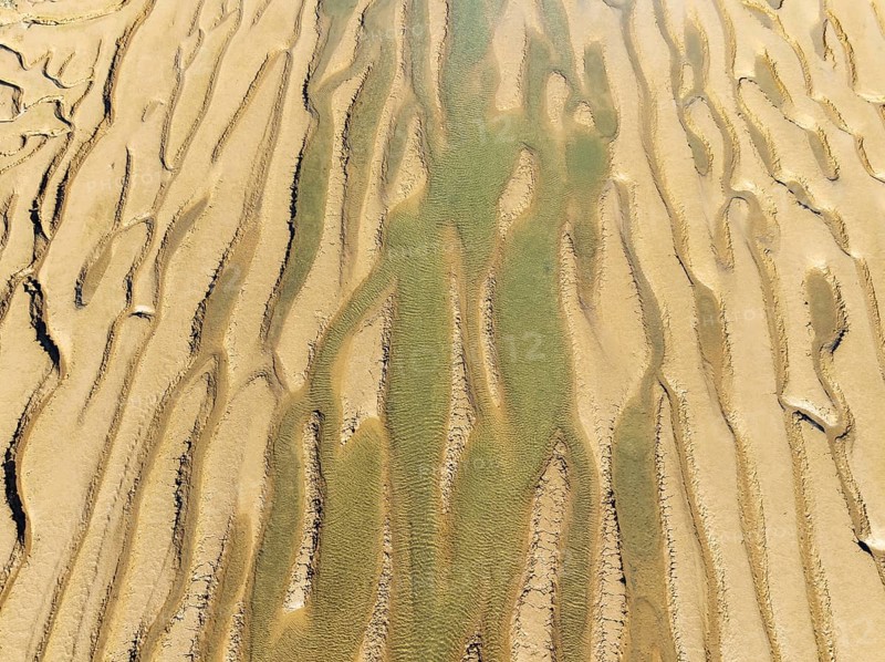 Network of channels and streams at low tide. In the marshland adjacent to the Odiel river. Aerial view. Drone shot. Huelva province, Andalusia, Spain, Europe