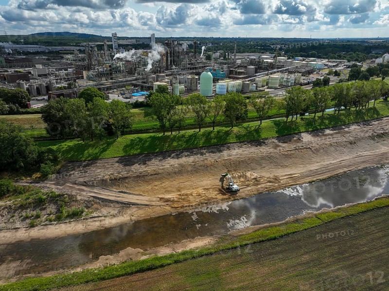 Oberhausen, North Rhine-Westphalia, Germany, renaturalisation of the Emscher in the Holtener Bruch. A new floodplain landscape for flood protection and biodiversity is being created here. In the background OQ Chemicals plant Ruhrchemie. The Emscher, which is currently straightened, is given curves again and can meander through its new floodplain. The ecological reorganisation of the Emscher system consists of the construction of a central wastewater treatment system in the Ruhr area, the construction of sewers and the renaturation of the Emscher and its tributaries. Following the construction of a parallel sewer, the Emscher has been completely free of sewage since January 2022. The river was previously an open, above-ground combined sewer with rainwater and wastewater, Europe
