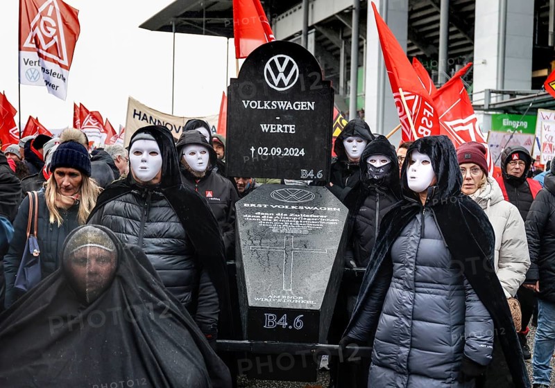 A symbolic VW coffin is carried by Volkswagen employees to the collective bargaining negotiations of Volkswagen and IG Metall in front of the Volkswagen Arena in protest against plant closures and redundancies, Wolfsburg, 21 November 2024, Wolfsburg, Lower Saxony, Germany, Europe