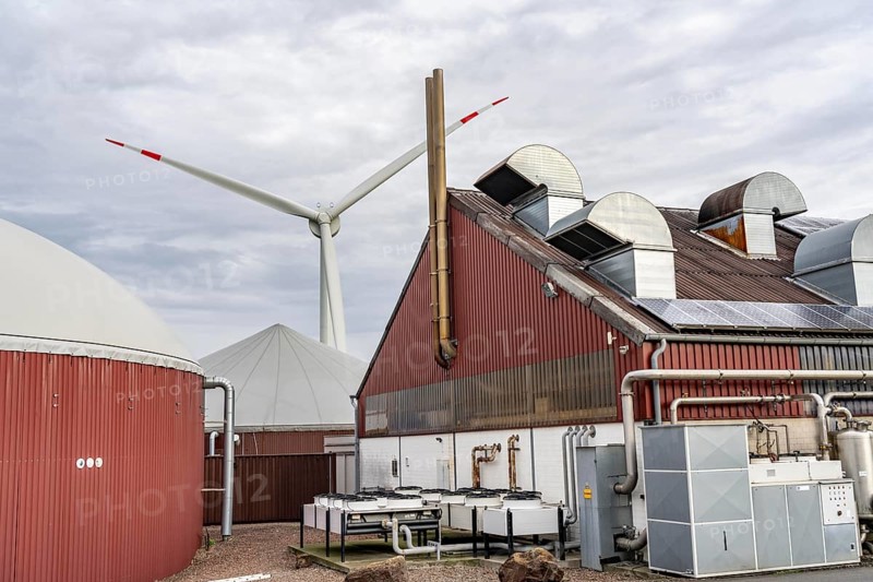 Biogas plant produces gas from various biomass, electricity is generated in combined heat and power plants with the biogas produced and sold to companies in the neighbouring industrial estate, the heat generated is fed into a local heating network, gas storage and wind power plant, Ense, North Rhine-Westphalia, Germany, Europe