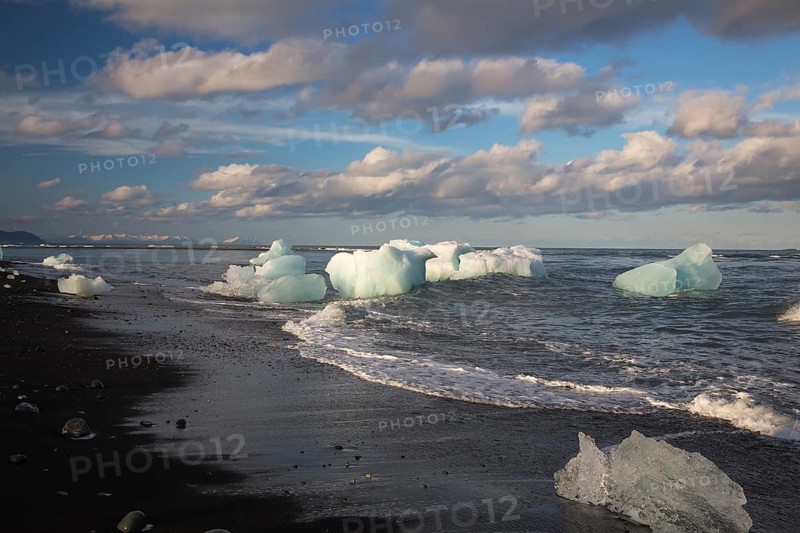 Little icebergs and crushed ice on the black beach at Joekulsarlon glacial lake