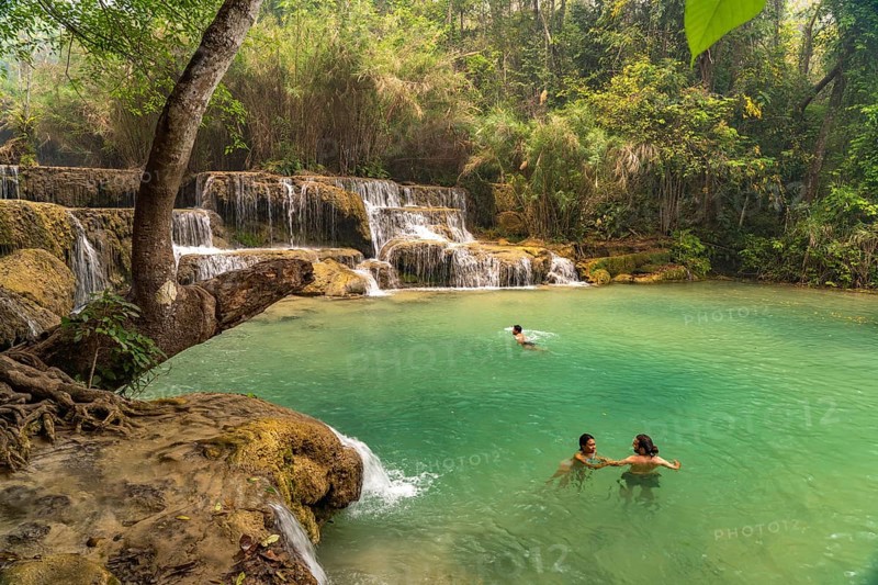 Tourists bathing in the Kuang Si waterfall near Luang Prabang, Laos, Asia