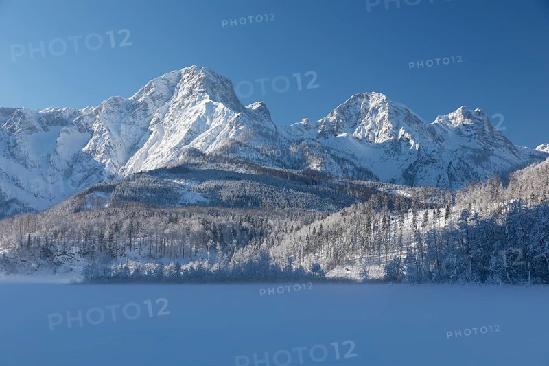 Lake Almsee frozen and snowcovered with the Totes Gebirge mountains in the background