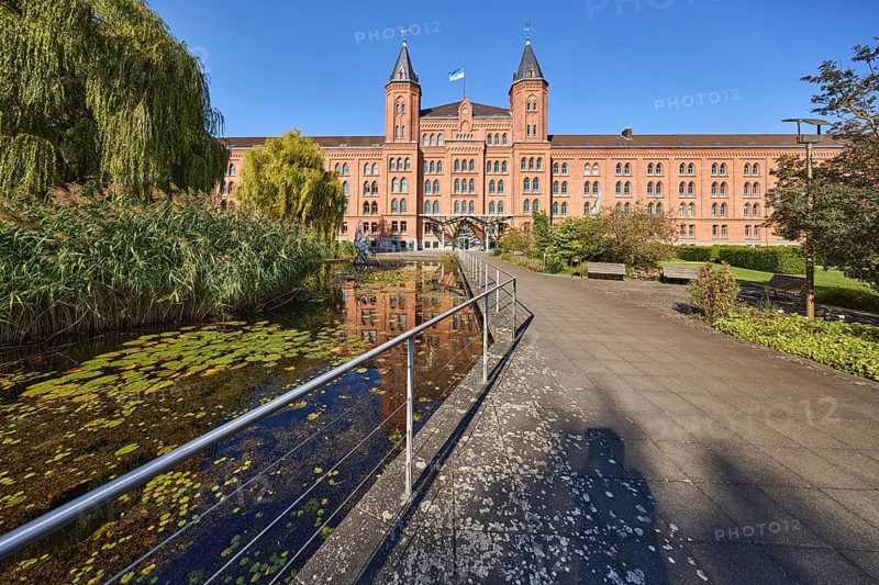 New town hall, brick architecture, architectural style neo-gothic, park, trees, footpath, pond, metal railing, blue sky, cloudless, street Am Französischen Garten, Celle, Lüneburger Heide, district Celle, Lower Saxony, Germany, Europe