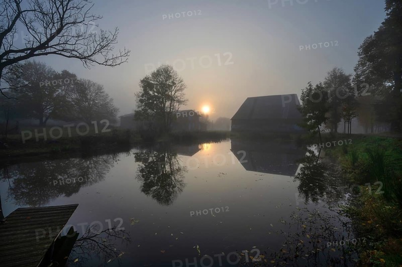 Morning sun over the estate pond on a foggy morning at Gut Othenstorf, Othenstorf near Rehna, Mecklenburg-Vorpommern, Germany, Europe
