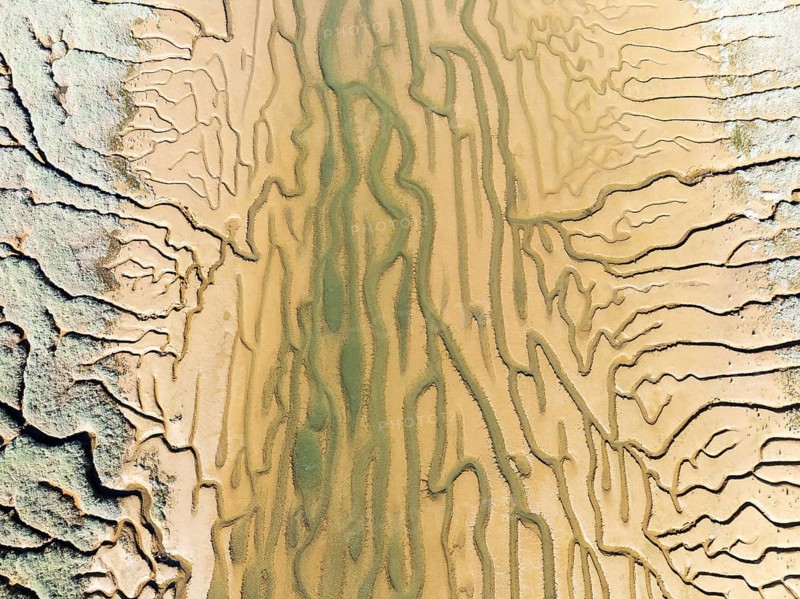 Network of channels and streams at low tide. In the marshland adjacent to the Odiel river. Aerial view. Drone shot. Huelva province, Andalusia, Spain, Europe