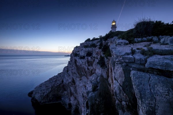 Lighthouse on a rocky cliff overlooking the calm evening sea, Lastovo, Neretva, Croatia, Europe
