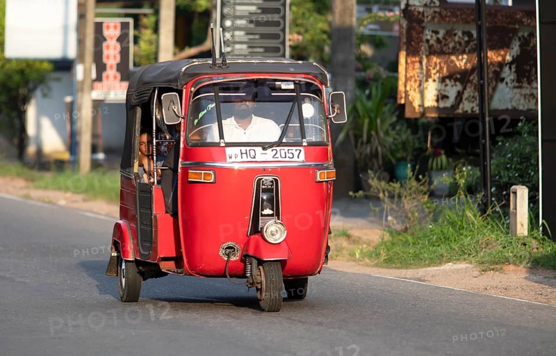 Red tuk tuk or autorickshaw with Sri Lankan passenger, Veyangoda, Western Province, Sri Lanka, Asia