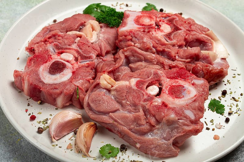 Raw steak, calf's neck on the bone, fresh meat, on a white plate, top view, no people