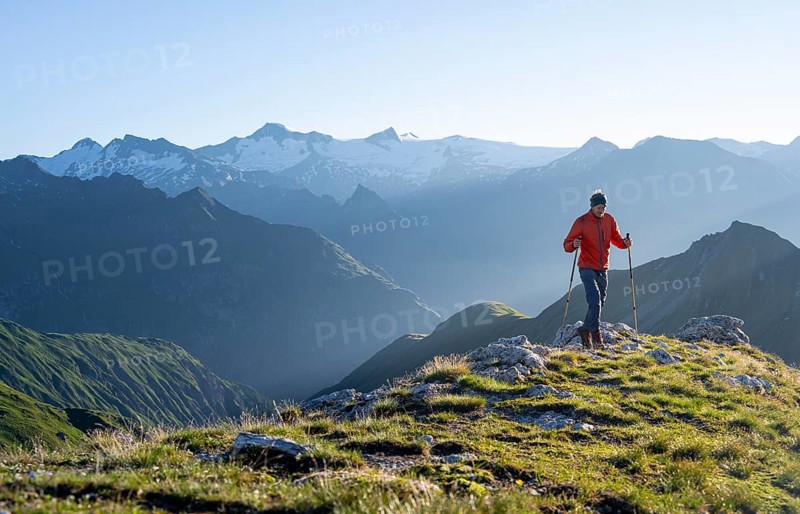 Hiker enjoying the mountain panorama in the morning, Venediger group, behind Dreiherrenkopf, Simonysitze and Großer Geiger, Hohen Tauern, Austria, Europe