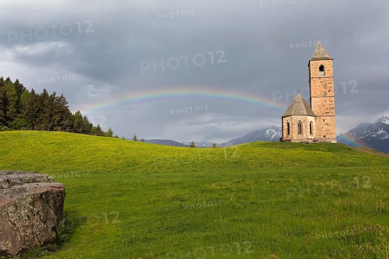 Church St. Kathrein, 39010 Hafling, Italy with a rainbow in the background. The church is from the 13 th century