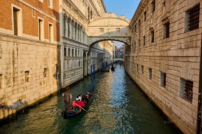 View from 'Ponte della paglia' on the bridge 'Bridge of Sighs' over a waterway on a sunny morning with gondolier in Venice on a foggy morning in winter, Italy, Europe
