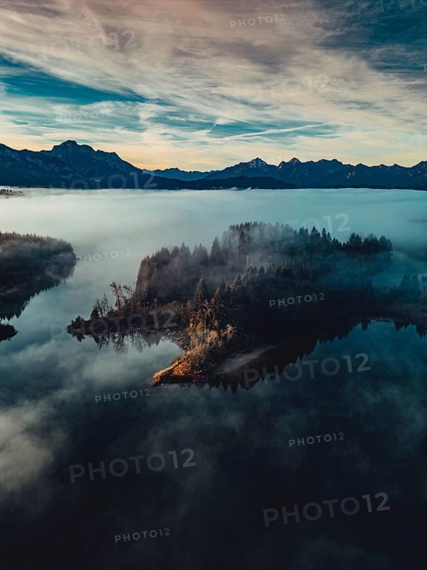 Autumn sunrise in the foothills of the Alps with fog at Illasbergsee and Forggensee near Halblech in Allgäu, Bavaria, Germany, Europe