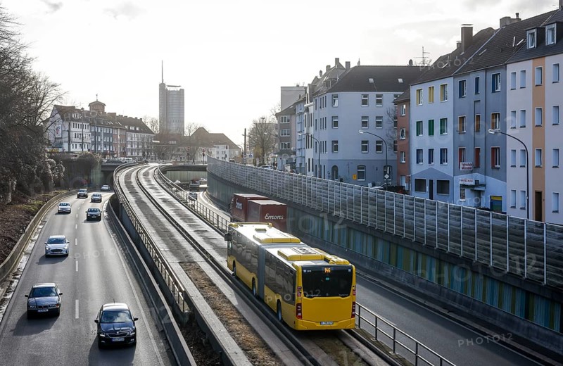 Essen, North Rhine-Westphalia, Germany - Cars and a public bus drive on the A40 motorway through the city centre of Essen, behind the Westenergie Tower, former RWE Tower