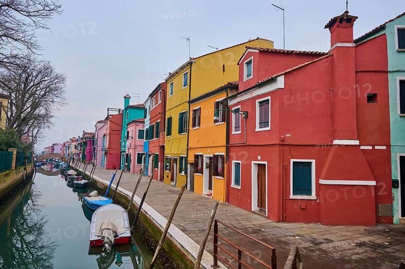 Colorful houses beside the waterway at 'Fondamenta di Terranova' with boats lying in the water on the island of Burano, Italy, Europe