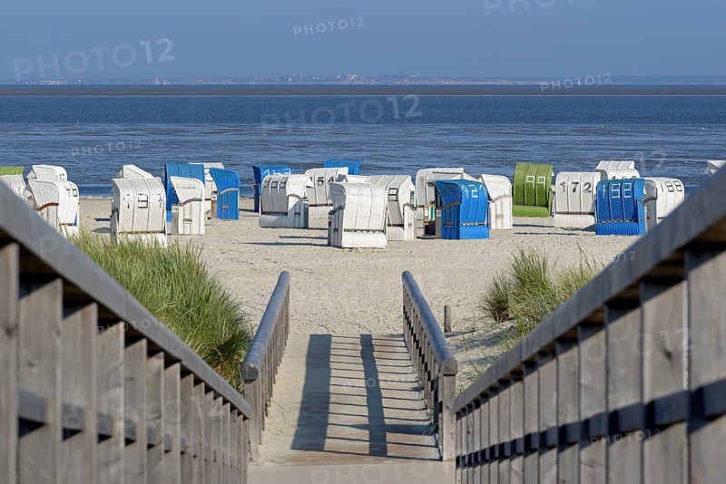 View from a wooden plank path to the beach with beach chairs, the island of Juist on the horizon, blue sky, North Sea, Norddeich, Lower Saxony, Germany, Europe
