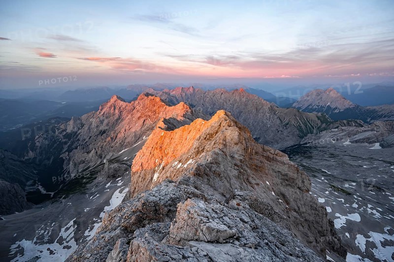 Impressive rocky mountain landscape, steep mountain ridge, Jubiläumsgrat with Alpspitze, mountain panorama from the summit of the Zugspitze, alpenglow at sunset, Northern Limestone Alps, Wetterstein Mountains, Bavaria, Germany, Europe